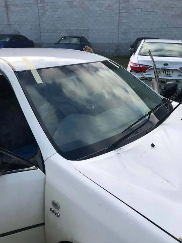 Family car with a newly fitted windscreen taped while the urethane cures